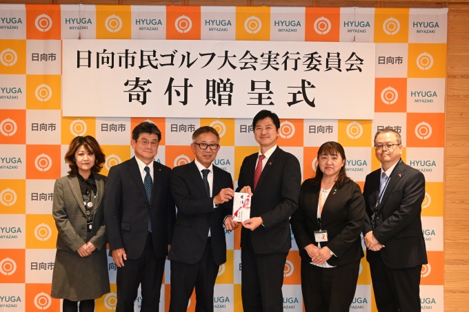 目録を手渡す伊東委員長(中央左)と受け取る西村市長(中央右)